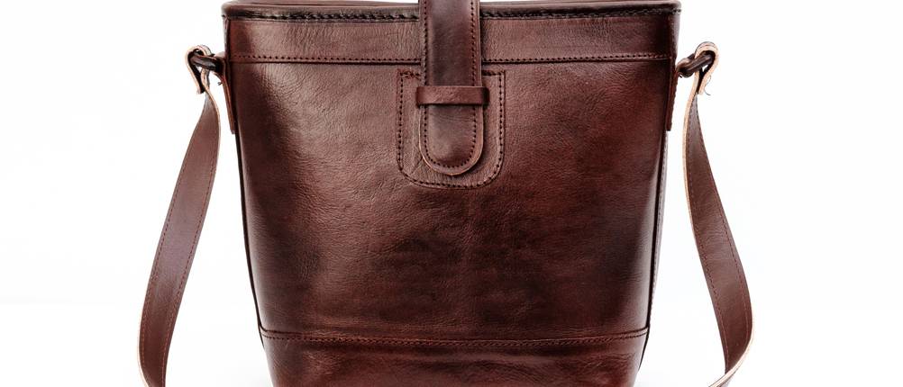 Umhängetaschen-Damen-Test: dunkelbraune Umhängetasche aus Leder vor transparentem Hintergrund