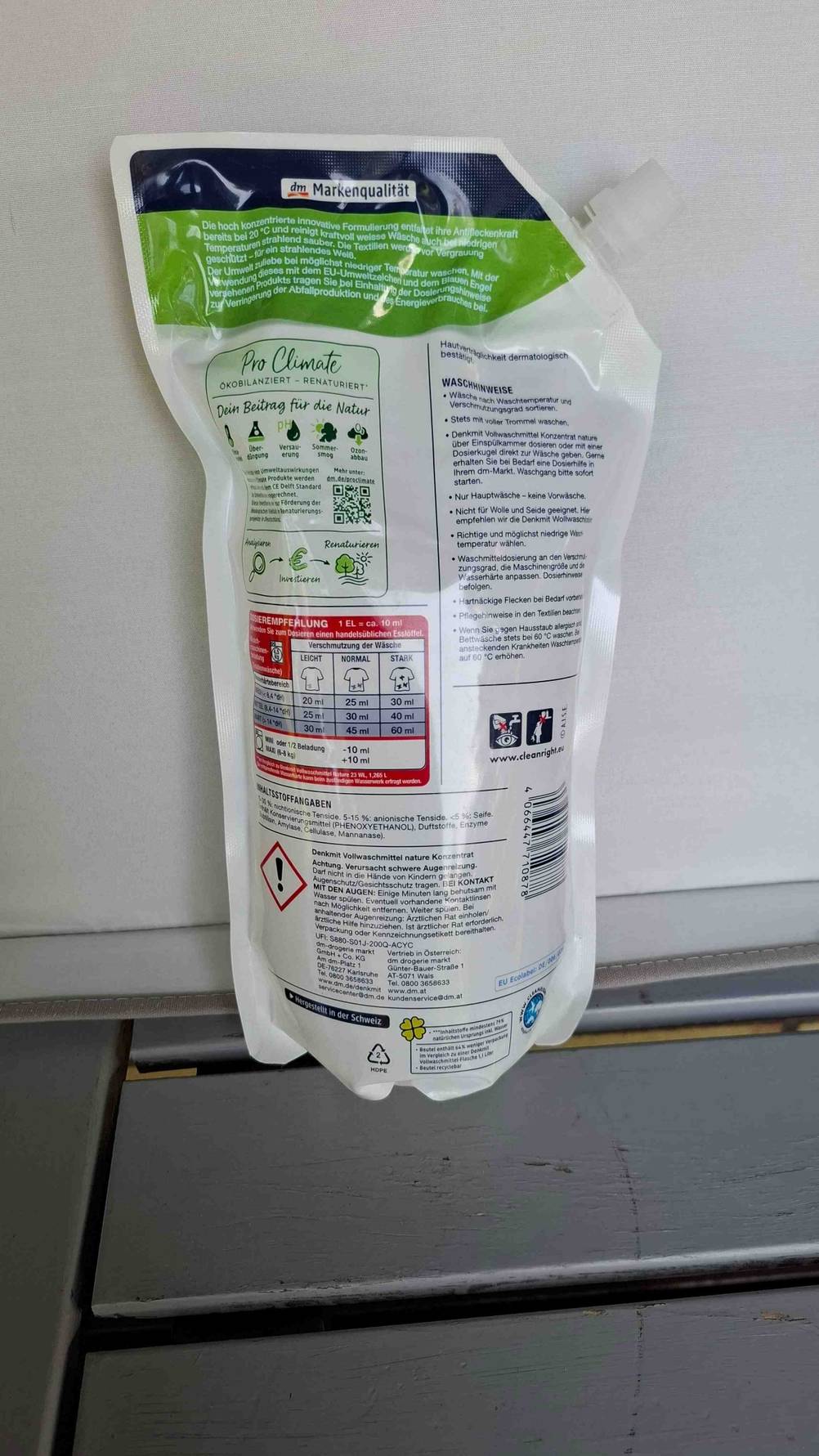 Ein umweltfreundliches Waschmittel mit der Rückseite nach vorne vor einer hellen Fläche.