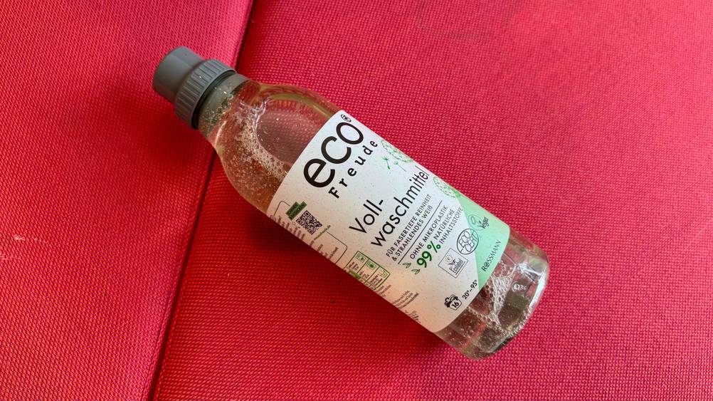 Umweltfreundliches Waschmittel-Test: Auf einem roten Polster liegt eine Flasche.
