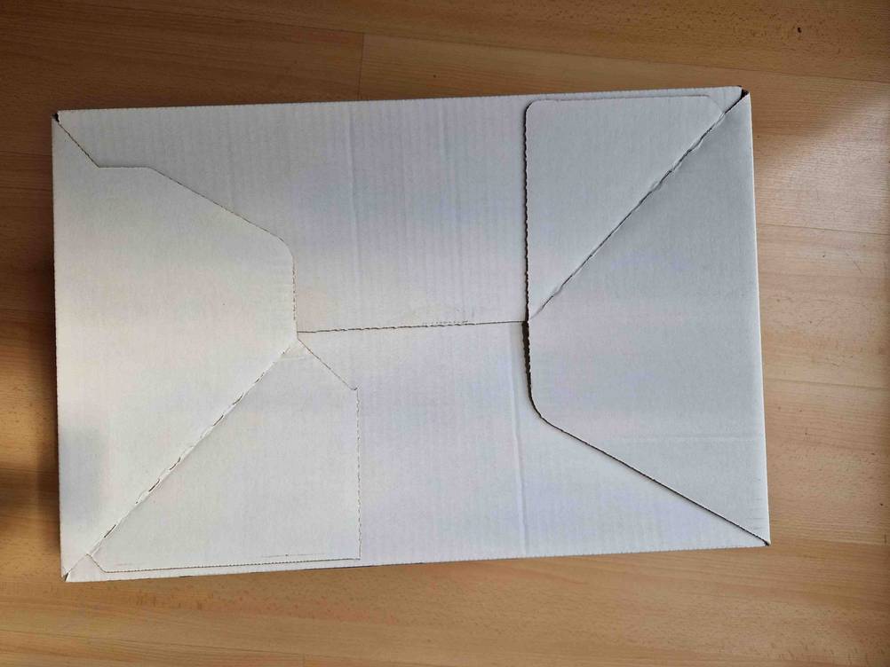 Die Unterseite des Umzugskartons im Test auf einem Holzboden.