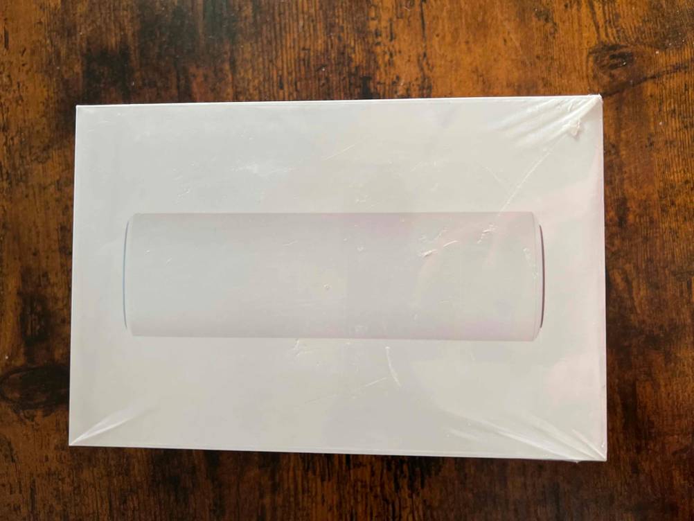Ein getestetes Mesh-WLAN in seiner Originalverpackung von oben auf einem Holztisch.