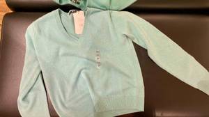 Im Test: Ein Kaschmir-Pullover für Damen liegt ausgebreitet auf einer dunklen Fläche.