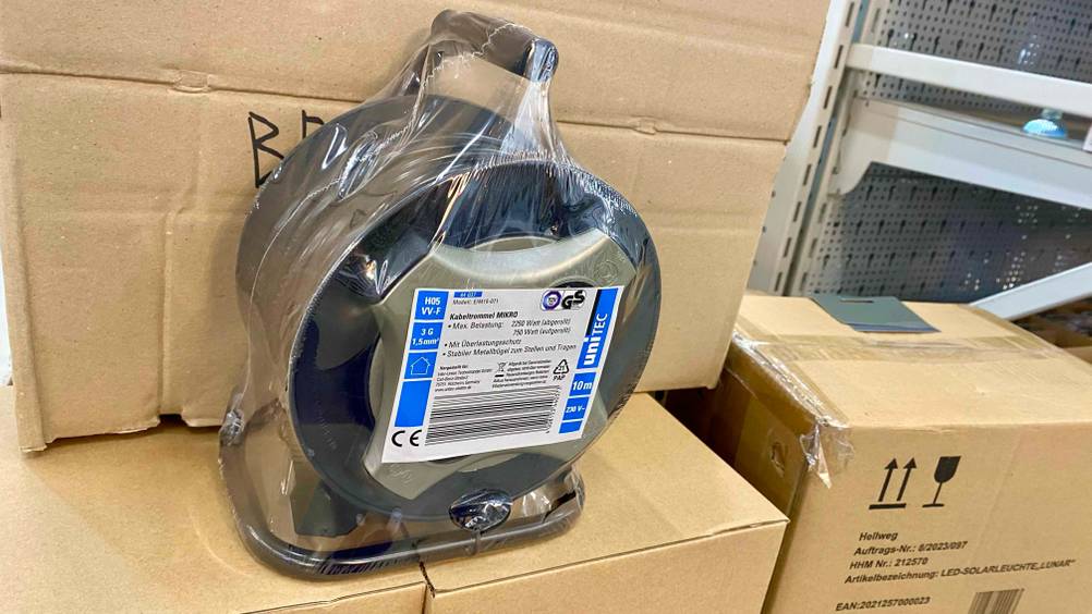 Im Test: Eine transparent verpackte Kabeltrommel steht auf mehreren Kartonagen.
