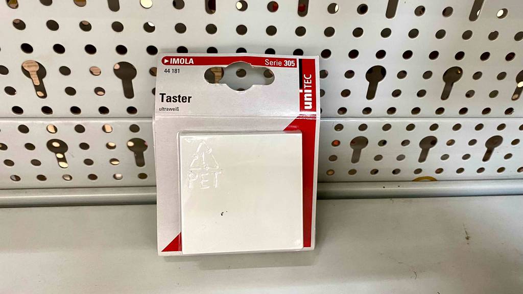 Taster-Test: ein ultraweißer Taster in seiner Verpackung vor einer weißen Lochwand im Verkauf.
