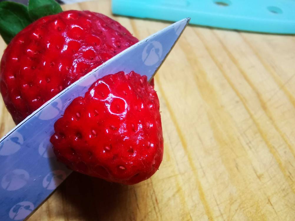 Ein Universalmesser im Test schneidet eine Erdbeere.