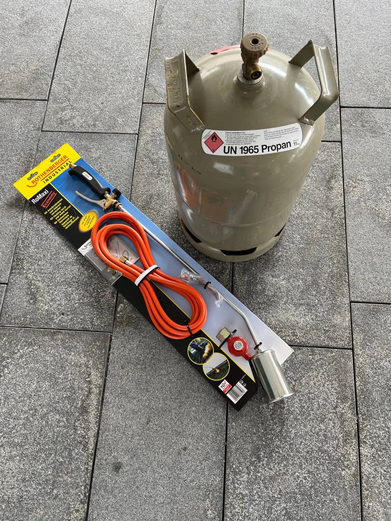 Unkrautbrenner mit Verpackung und Propangasflasche.