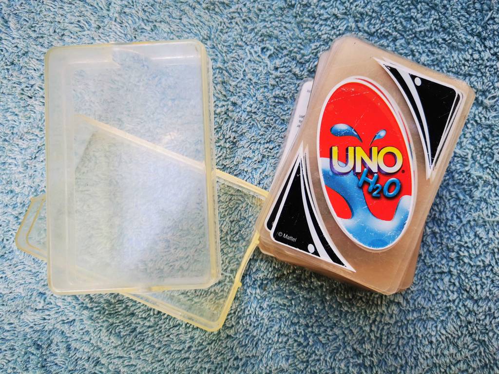 Ein Stapel UNO-Karten liegt zum testen neben der Aufbewahrungsbox.