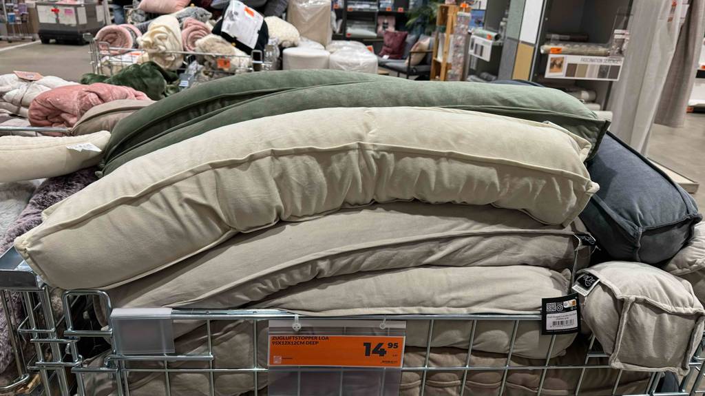 Zugluftstopper im Test: Mehrere Modelle inklusive Preisschild liegen in einem Verkaufskorb.