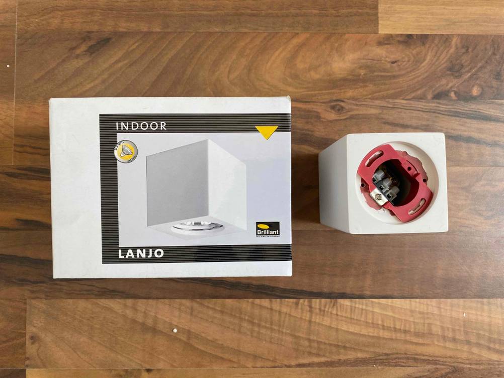 Unterbauleuchte getestet: Neben der Originalverpackung steht die Unterbauleuchte auf einer Holzfläche.