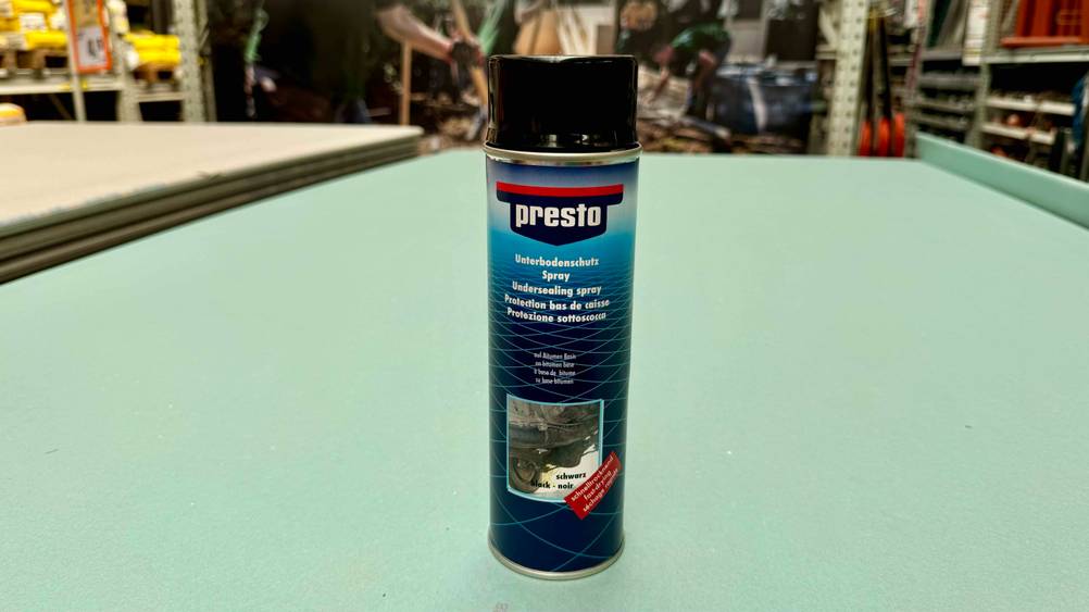 Unterbodenschutz im Test: Eine Dose von vorne auf einer blauen Fläche in einem Verkaufsladen.