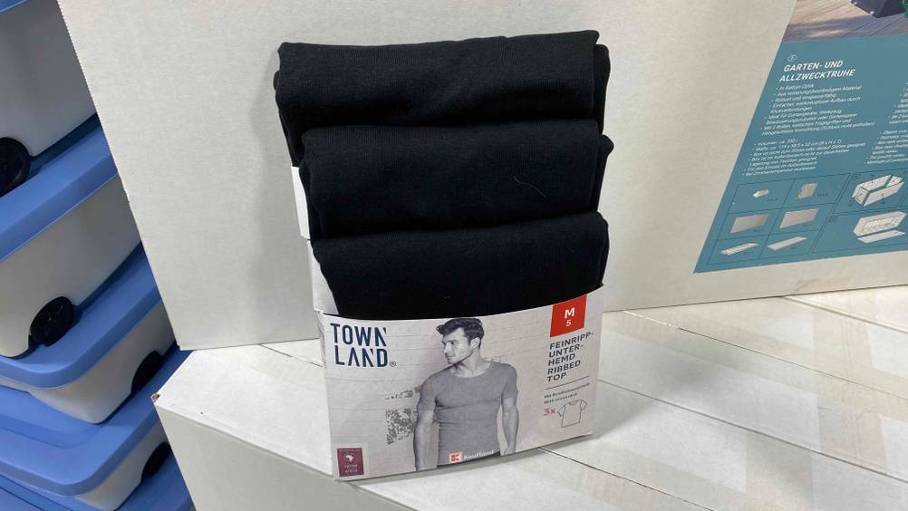 Mehrere Unterhemden für Herren im Test: Auf dem Regal steht eine Packung mit Unterhemden für Herren. 