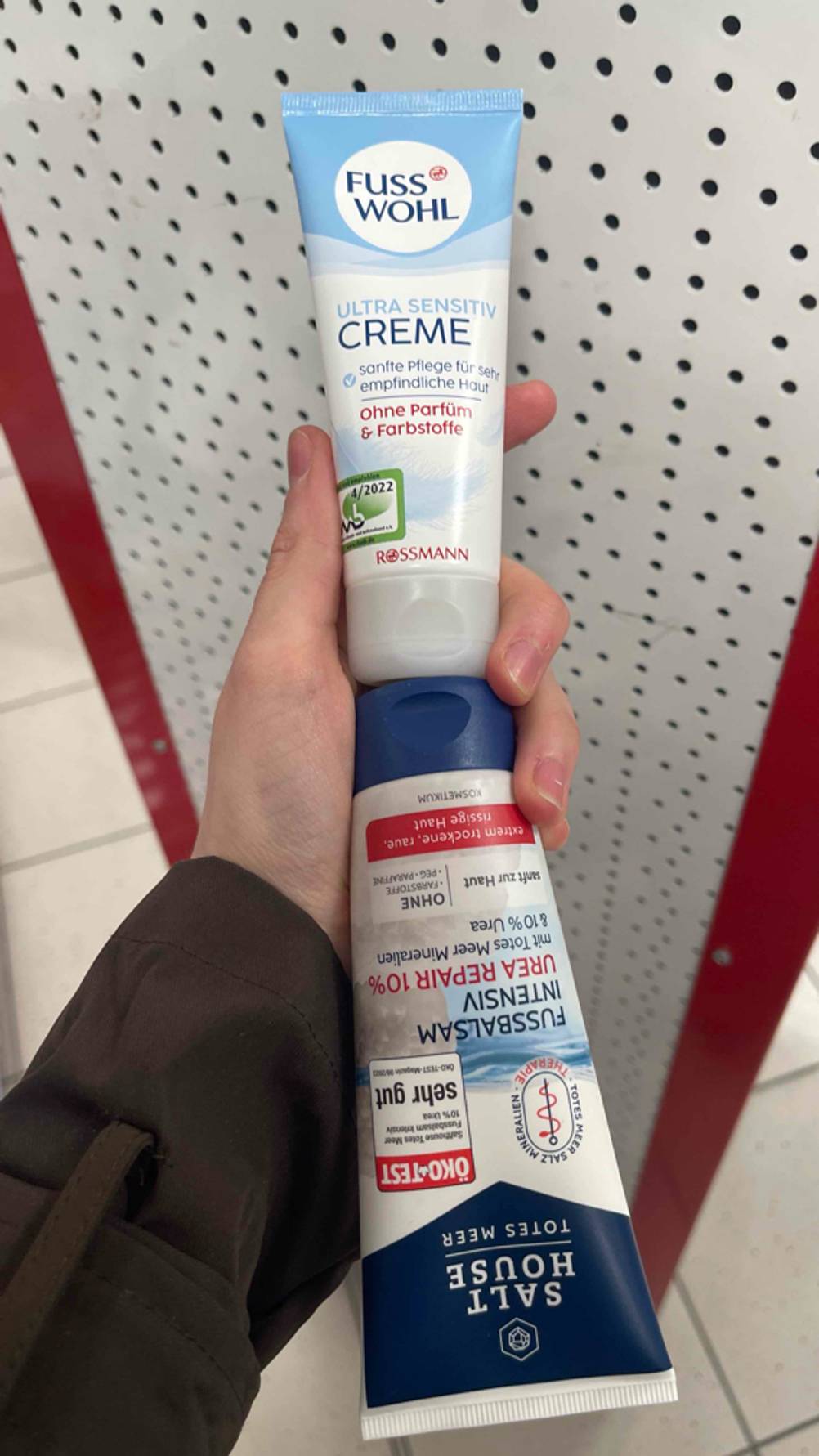 Urea-Fußcreme-Test: Eine Hand hält zwei verschiedene Sorten Deckel an Deckel.
