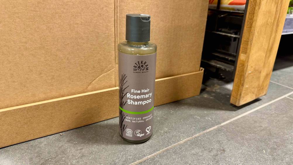 Eine Flasche des getesteten Urtekram-Shampoos steht auf dem Boden.