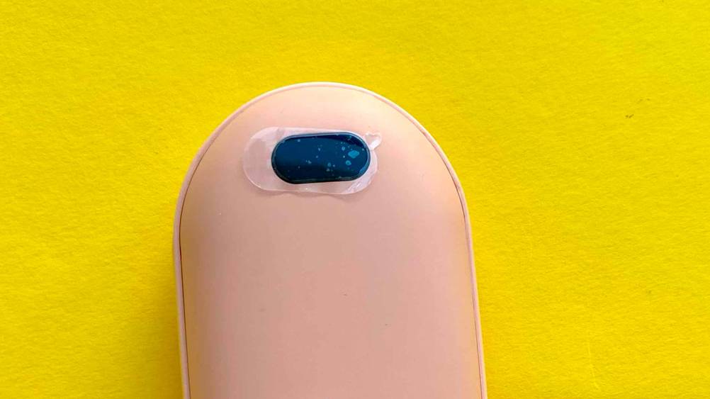 Nahaufnahme der Oberseite eines getesteten USB-Handwärmers auf einer gelben Fläche.