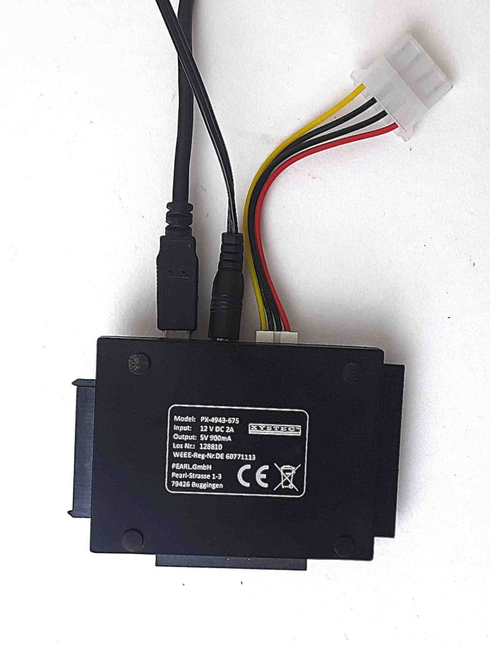 Der getestetete USB-SATA-Adapter mit der Rückseite nach oben auf einer hellen Fläche.