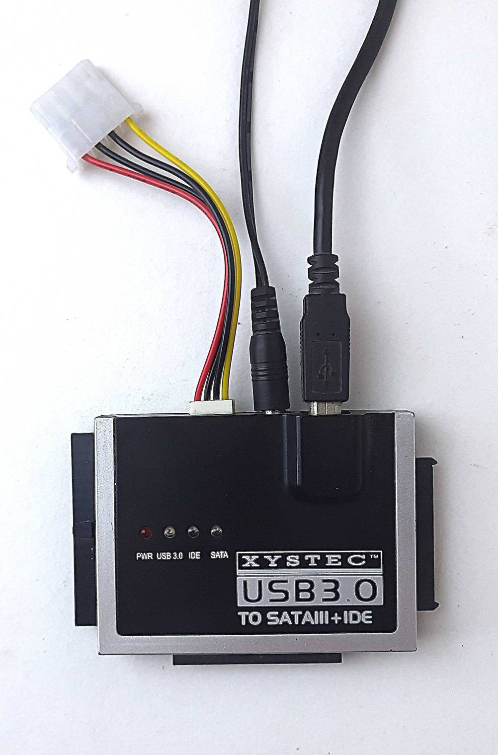 Der USB-SATA-Adapter im Test auf einer hellen Fläche liegend.