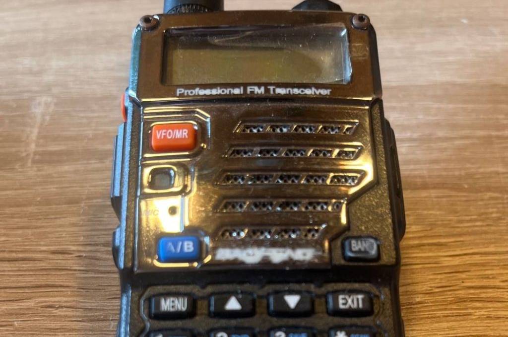 Funkgeräte-Test: Ein schwarzes Modell UV-5RE von Jucjet liegt ausgeschaltet auf einer Holzfläche.