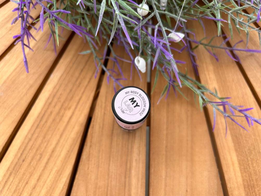 Nahaufnahme des Deckels eines getesteten UV-Nagellacks auf einem Holztisch.