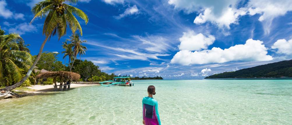 UV-Shirt-Damen-Test: Eine mit einem UV-Shirt bekleidete Frau steht im Wasser.