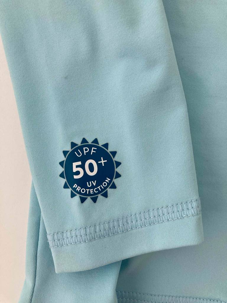 Nahaufnahme des UV-Protektion-Etiketts am Arm des hellblauen UV-Shirts für Kinder im Test.