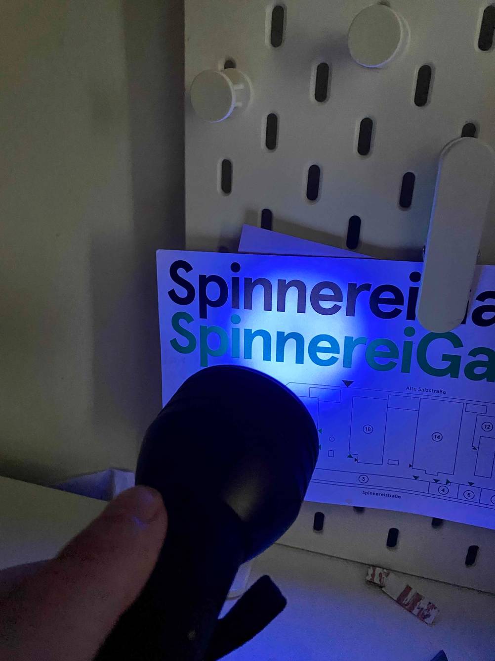 Getestet: Eine UV-Taschenlampe leuchtet auf ein Stück Papier.