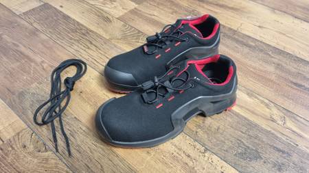 Sicherheitsschuhe auf einem Holzuntergrund stehend.