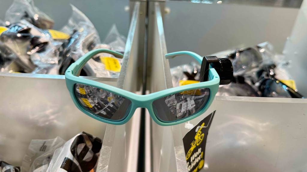 Kinder-Fahrradbrillen-Test: Das türkisfarbene Modell mit getönten Gläsern hängt an einem Ausstellungsregal.