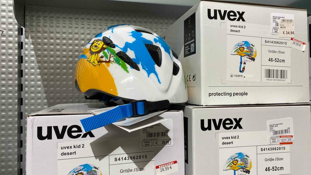 Uvex-Fahrradhelm-Test: Das bunte Modell Uvex Kid 2 liegt auf seiner Verpackung im Regal.