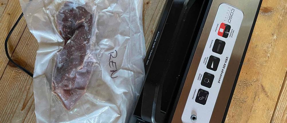 Ein getesteter Caso-Vakuumierer liegt neben einem eingeschweißten Steak.