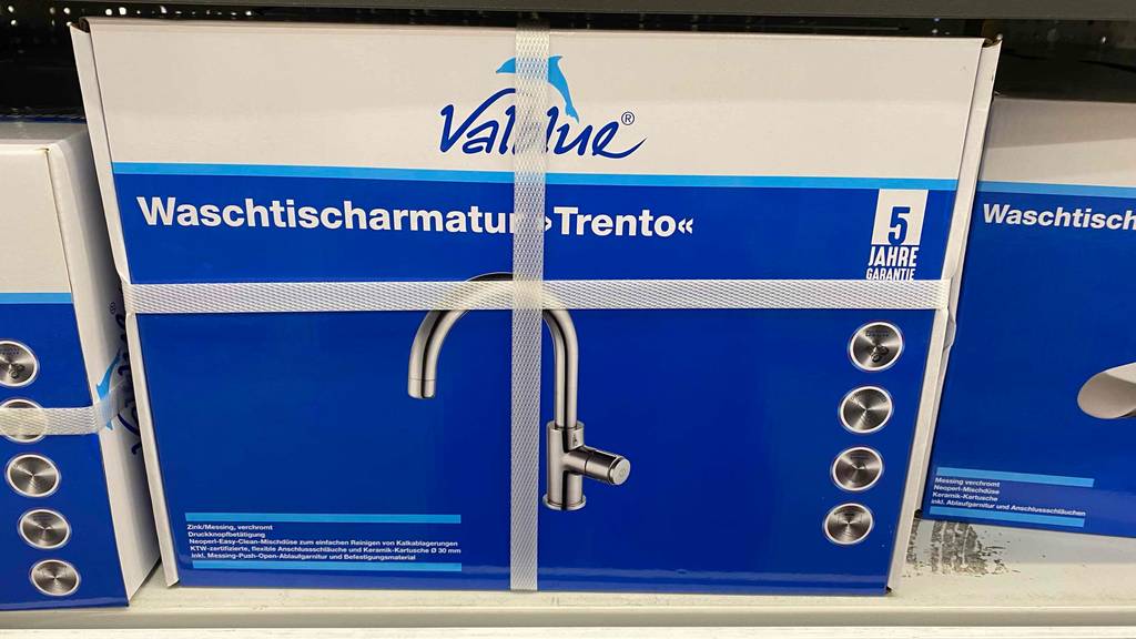 Eine weiß-blaue Verpackung inklusive getesteter Waschtischarmatur Trento der Marke Valblue steht neben anderen Verpackungen in einem Verkaufsregal.