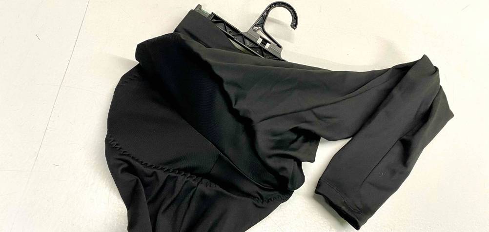 Fahrradhose-Damen-Test: schwarzes Modell am Kleiderbügel vor heller Fläche mit Fokus auf den gepolsterten Sitzbereich.