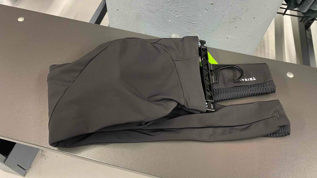 Eine getestete Fahrradhose lang liegt zusammengelegt auf einer dunklen Fläche.