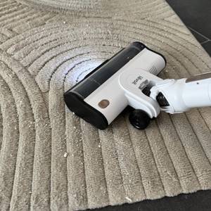 Vanish-Teppichreiniger-Reste werden mit einem Staubsauger von einem Teppich gesaugt.