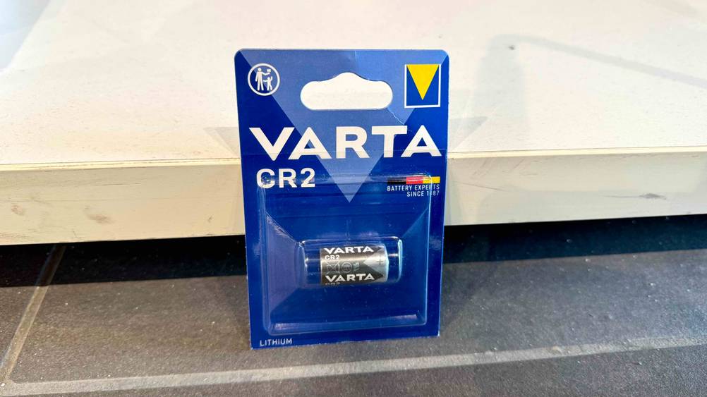 Vor einer hellen Wand auf dem Boden lehnt eine Varta-Batterie im Test.