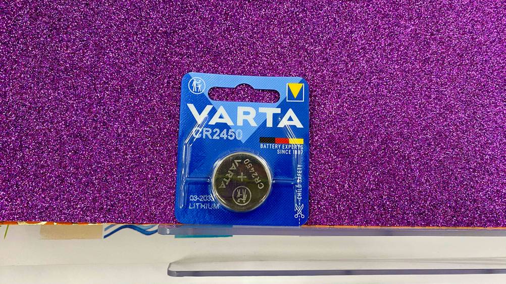 Varta CR2450 im Test: Lithium-Knopfzelle liegt auf violettem Untergrund.