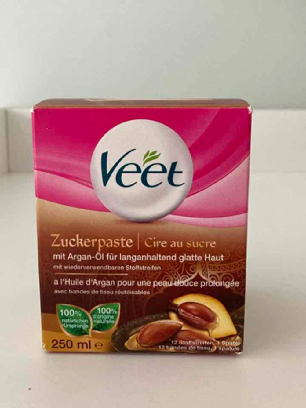In einer VEET-Verpackung befindet sich die getestete Zuckerpaste mit Argan-Öl auf einem beigefarbenen Regal.