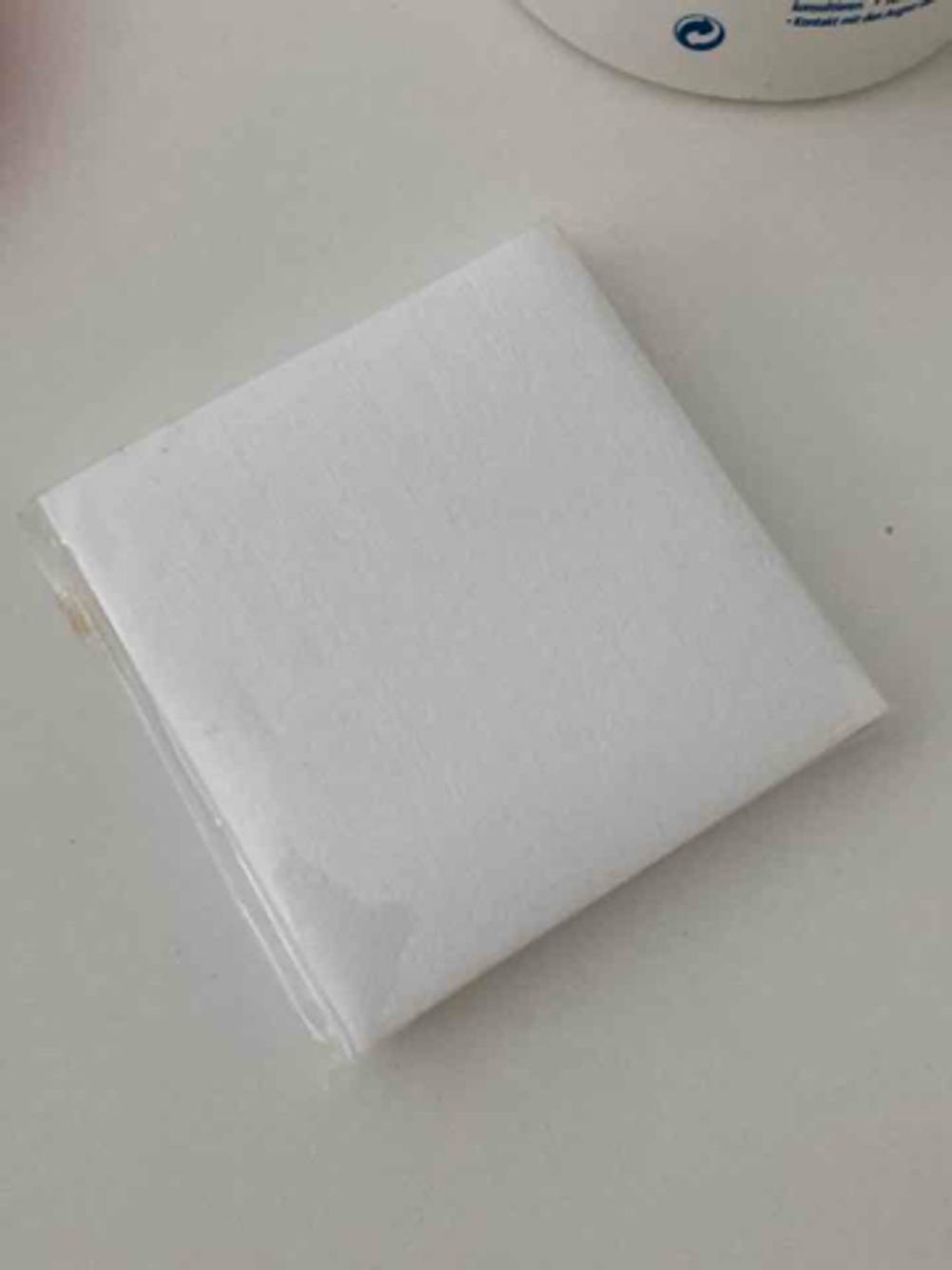 Zuckerpaste-Test: Ein weißes Flies liegt auf einer beigefarbenen Oberfläche.