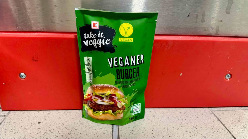 Vegane Burger-Patties im Test: Eine Packung vor einer roten Leiste am Boden stehend.