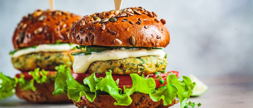 Vegane-Burger-Patties-Test: Zwei vegane Burger mit Gemüse und Salat gefüllt. 