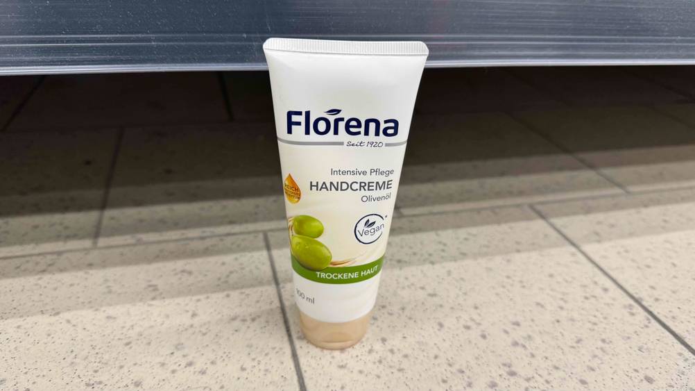 Eine getestete vegane Handcreme steht vor einem Regal auf dem Boden.