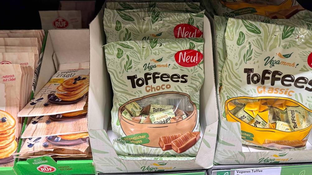 Vegane Süßigkeiten-Test: Mehrere Packungen liegen in einem Verkaufsregal neben anderen Produkten.