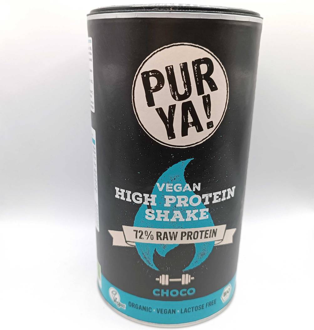 Eine Dose des getesteten veganen Proteinpulvers von vorne auf einer hellen Fläche.