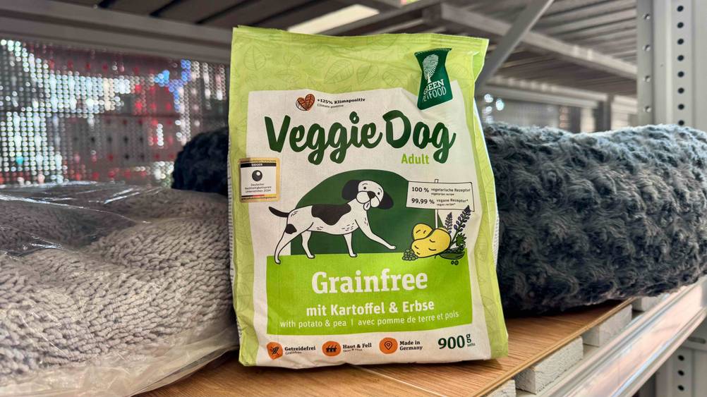 In einem Regal vor Hundebetten steht das vegetarische Hundefutter im Test.