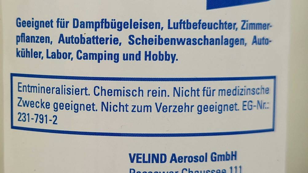 Auf einer Flasche getestetes destilliertes Wasser stehen Anwendungs- und Verwendungshinweise.