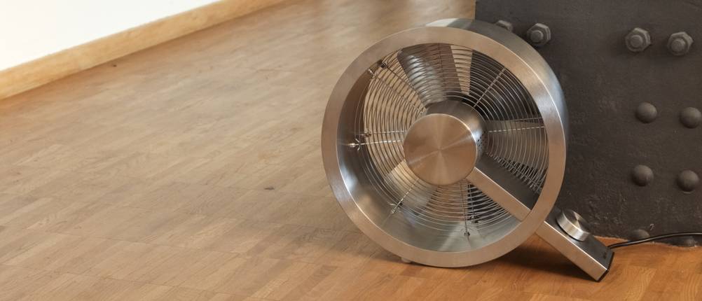 Ventilator stadler Form Q steht auf dem Boden neben einem Metallträger.