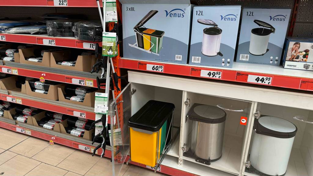 Ein Einbau-Abfalleimer ist zum Testen neben anderen Abfalleimern in einem Verkaufsregal eingebaut.