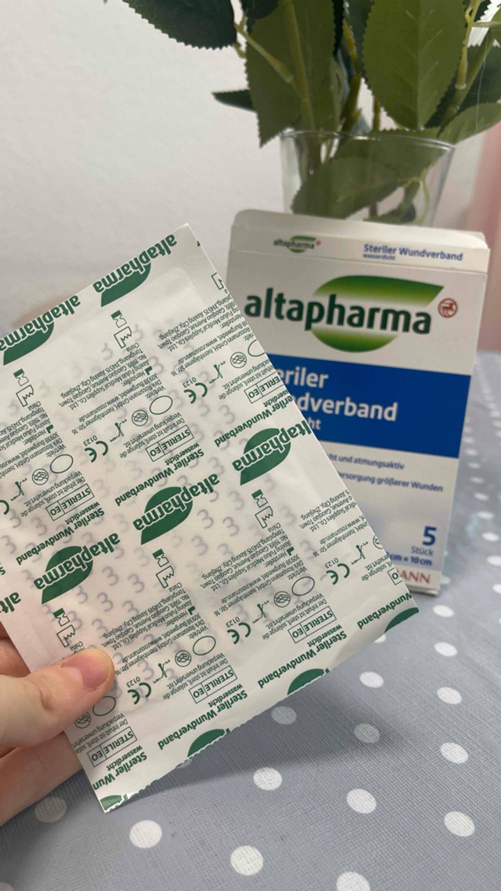 Eine Hand hält einen verpackten Verband zum testen.