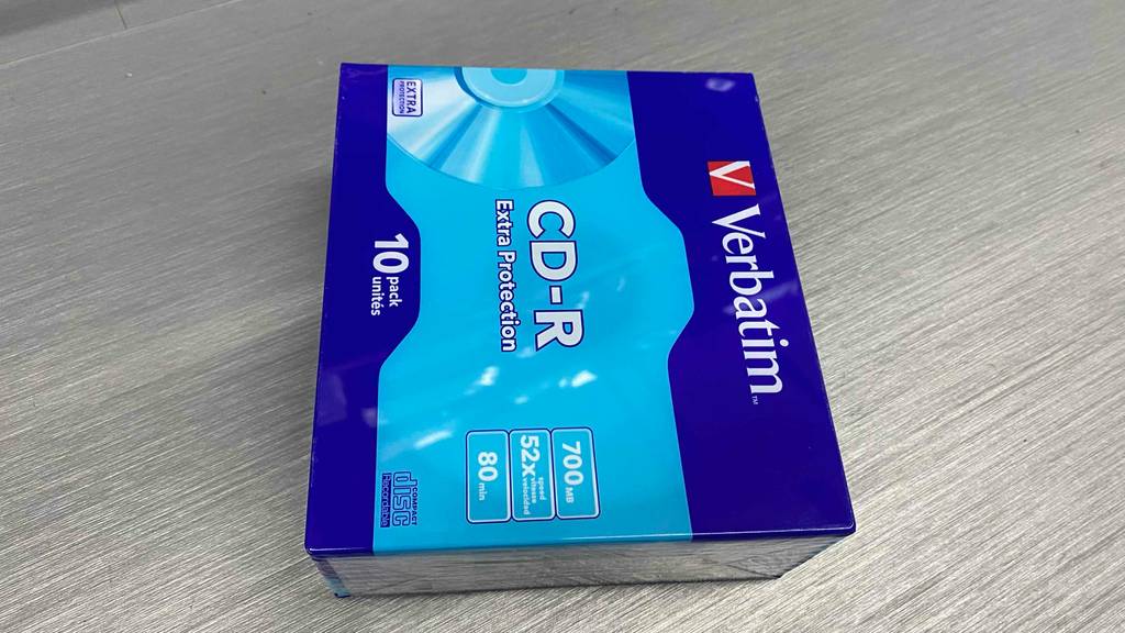 Ein 10er Pack Verbatim CD-R liegt zum testen quer auf grauem Laminat.