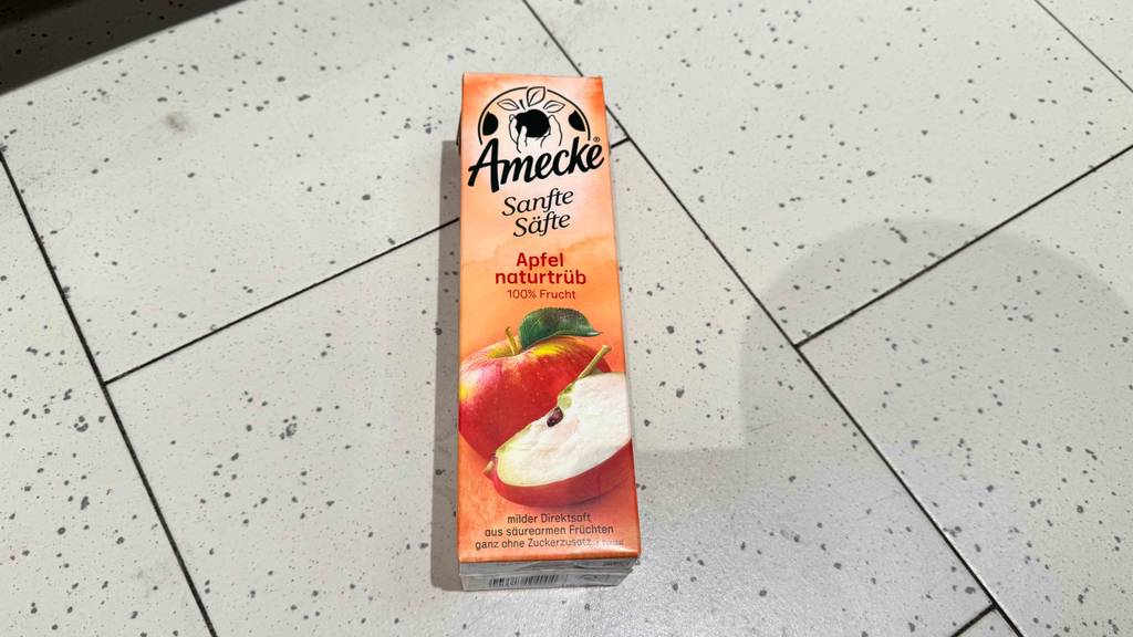 Naturtrüber Apfelsaft im Test: Ein Tetrapak der Marke Amecke liegt auf einem Fliesenboden.