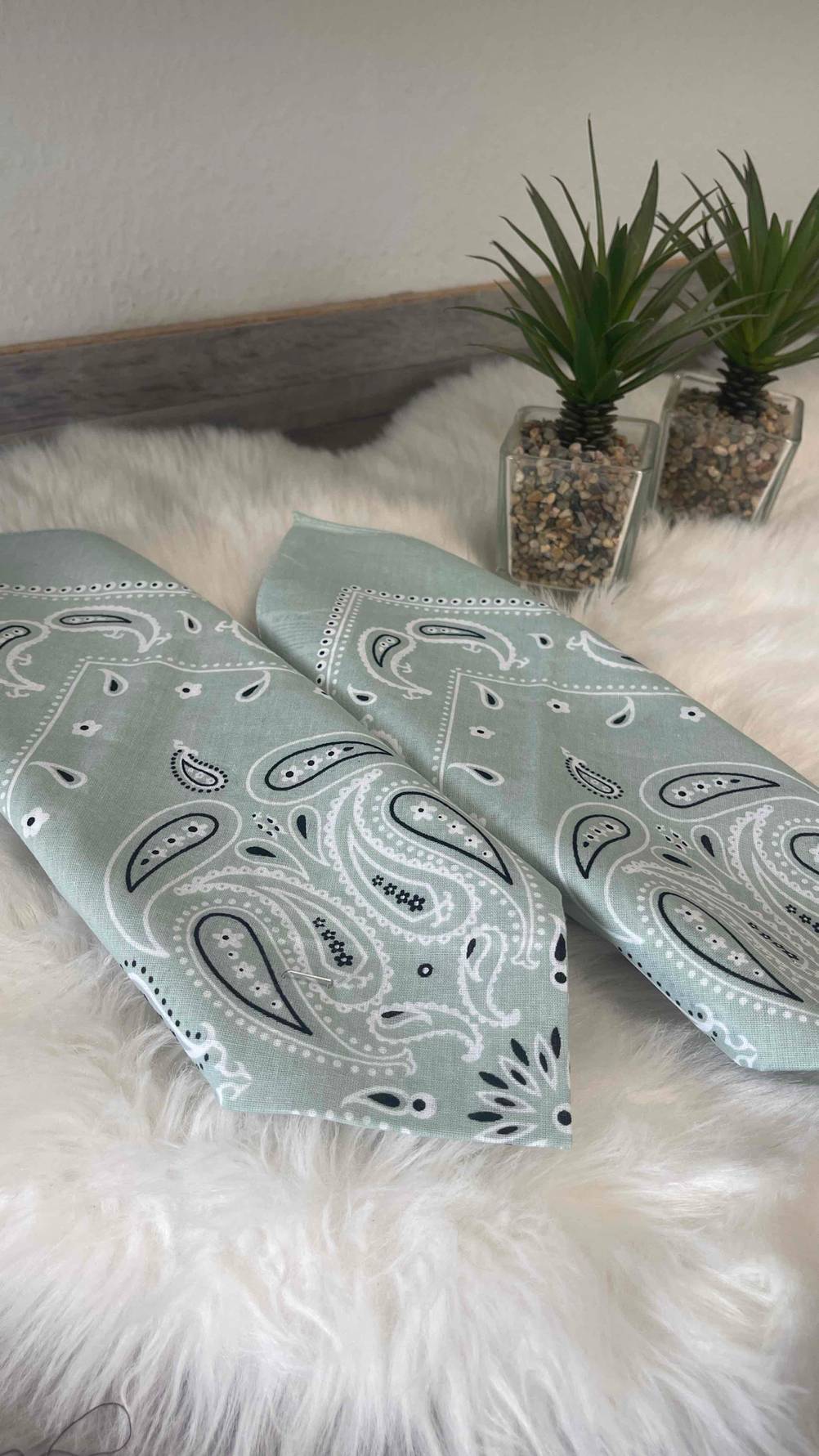 Die beiden getesteten Bandanas liegen nebeneinander auf einem Fell.